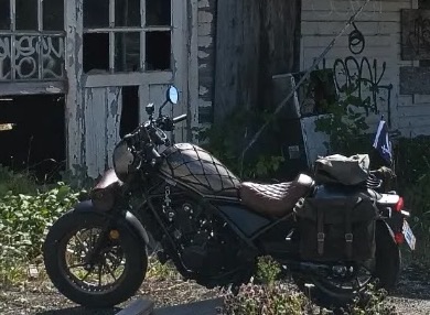 Rebel parked by an old red house